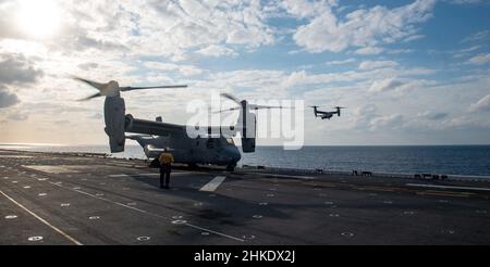 PHILIPPINISCHES MEER (Feb 1, 2022) ein Tiltrotor-Flugzeug der Marine Expeditionary Unit 31st (MEU) MV-22B von Osprey landet auf dem Flugdeck des nach vorne eingesetzten amphibischen Sturmschiffs USS America (LHA 6). Amerika, Flaggschiff der America Amphibious Ready Group, arbeitet zusammen mit der 31st MEU im Verantwortungsbereich der US-Flotte für 7th, um die Interoperabilität mit Verbündeten und Partnern zu verbessern und als einsatzbereite Einsatztruppe für Frieden und Stabilität in der Indo-Pazifik-Region zu dienen. (USA Navy Foto von Mass Communication Specialist 3rd Class Matthew Cavenaile) Stockfoto