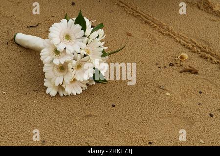 Schöner weißer Brautstrauß auf dem Sand Stockfoto