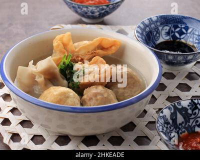 Bakso Malang, Fleischballsuppe mit verschiedenen Beilagen wie Tofu Fried Shiumay oder Bakso Goreng. Serviert auf dem Tisch mit Sambal, Soysauce und Tomato Sau Stockfoto