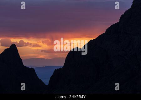 Spektakuläre Sonnenuntergänge treten im Big Bend National Park auf, vor allem, wenn man durch die Kerbe in den Chisos Mountains, bekannt als „das Fenster“, schaut. Stockfoto