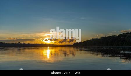 Amazonas-Regenwald-Sonnenuntergangspanorama entlang des Pastaza-Flusses, Ecuador. Stockfoto