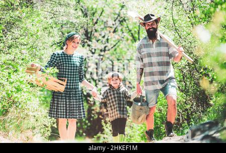 Familie arbeitet zusammen auf dem Bauernhof. Landleben. Familie zu Fuß in landwirtschaftlichen Bereich. Familiengärtner. Konzept zur Herstellung von Bio-Lebensmitteln. Stockfoto
