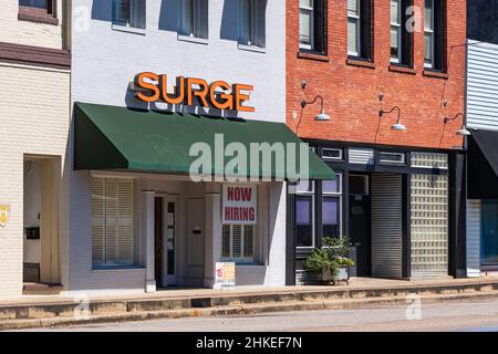 Greenville, Alabama, USA-Sept. 24, 2021: Gebäude in der Innenstadt von Greenville mit großem "Now Hiring"-Schild vor der Tür, ein Zeichen für die weit verbreitete Arbeitskräftemangel Stockfoto