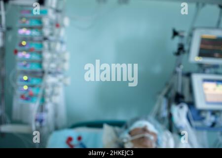 Patient unter der Überwachung auf der Intensivstation, unfokussierter Hintergrund. Stockfoto
