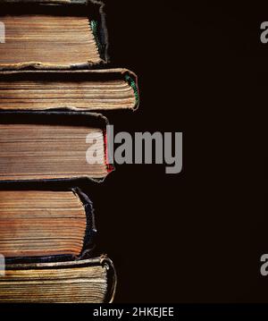 Ein Stapel von einem alten vergilbten Bücher mit Alter auf dem schwarzen Hintergrund mit leerem Platz für Text einfügen. Stockfoto