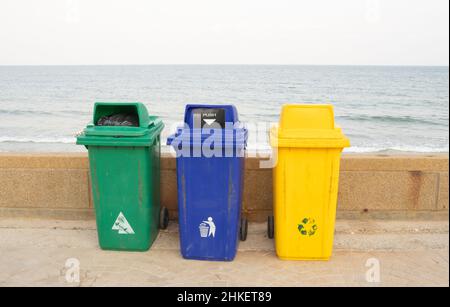 Drei Metallbehälter für verschiedene Abfälle mit einer Aufschrift auf türkisch und englisch - Papier, Glas, Kunststoff stehen im Park. Trennung und Sortierung Stockfoto