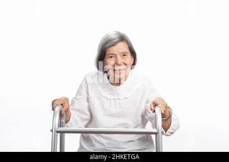 Porträt einer niedlichen lächelnden älteren asiatischen Frau, die isoliert auf Weiß auf die Kamera schaut. Ältere alte Dame Nahaufnahme Porträt. Stockfoto