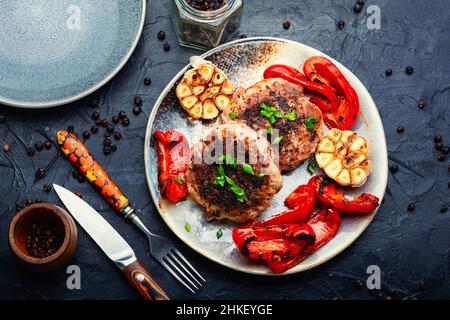 Gegrilltes Rindersteak, Rind- und Schweinefleisch mit Gewürzen. Gehacktes Hacksteak und Wacholderbeeren Stockfoto