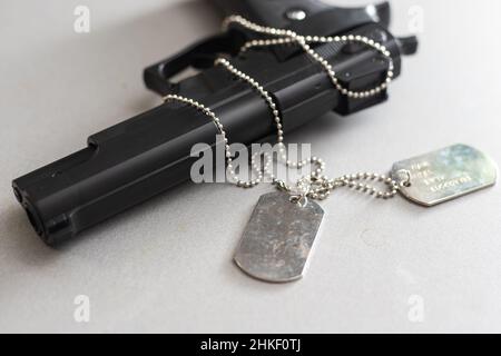 Pistole mit Dogtags. Konzept von Dienst und Dienst in US-Streitkräfte. Veteranenkonzept Stockfoto