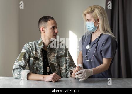 Arzt mit Militäroffizier Patient im Krankenhaus Stockfoto