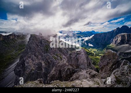 Luftaufnahme über die Gipfel der Puez-Gruppe hinunter nach Corvara und das Tal von Badia, bedeckt von Wolken, vom Gipfel des Grand Cirus aus gesehen. Stockfoto