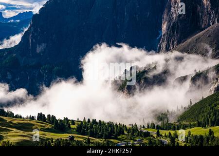 Luftaufnahme zu den Felswänden der Sellagruppe und dem Tal von Badia, bedeckt mit Wolken, vom Gipfel des Grand Cir aus gesehen. Stockfoto