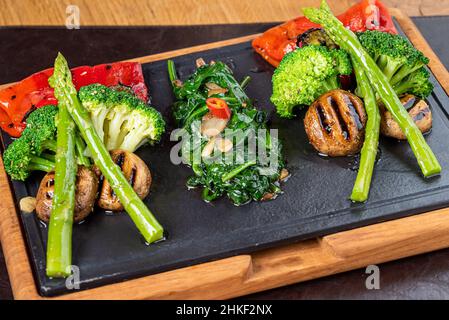 Gesunde gegrillte Gemüseplatte mit Pilzen, Brokkoli, Paprika, Spargel und Spinat Stockfoto