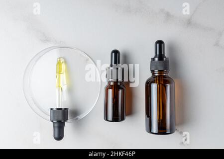 Set von unbranded dunklen Glasflaschen für Design. Ätherisches Öl, Gesicht Serum in Mock-up-Paket. Minimalistischer Style. Trendiges Konzept. Draufsicht. Stockfoto