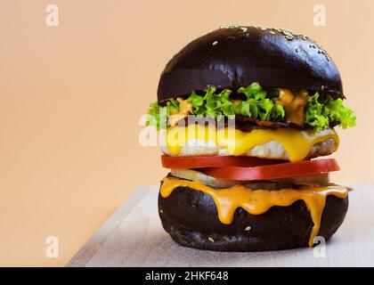 Hühnerburger in einem schwarzen Brötchen Stockfoto