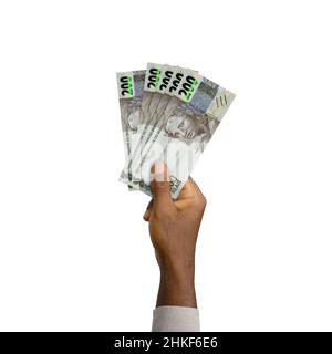 Schwarze Hand mit 3D gerenderten 200 brasilianischen Reiznoten isoliert auf weißem Hintergrund. Brasilianische echte Noten Stockfoto