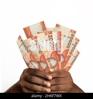 Schwarze Hände mit 3D gerenderten chilenischen Peso-Noten. Nahaufnahme der Hände mit chilenischen Währungsscheinen Stockfoto