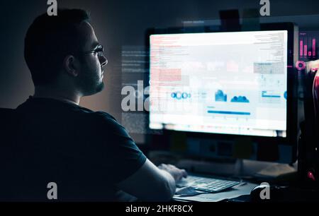 Entwicklung läuft. Ausgeschnittene Aufnahme eines jungen Computerprogrammierers, der Daten durchschaut. Stockfoto