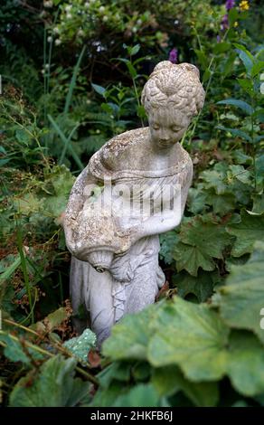 Loozen, Niederlande - Aug 17 2021 Eine Gartenstatue einer Frau, die Wasser aus einem Krug in den Ada Hofmans Pond Gardens gießt Stockfoto