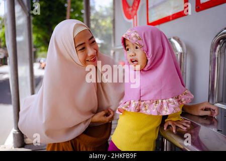 Kleines Mädchen mit Hijab wartet zusammen an der U-Bahn-Station Stockfoto