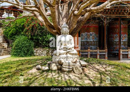 Buddha-Statue unter einem Bodhi-Baum an der Pagode Khamsum Yeulley Namgyal Chorten in Punakha, Zentral-Bhutan, Asien Stockfoto