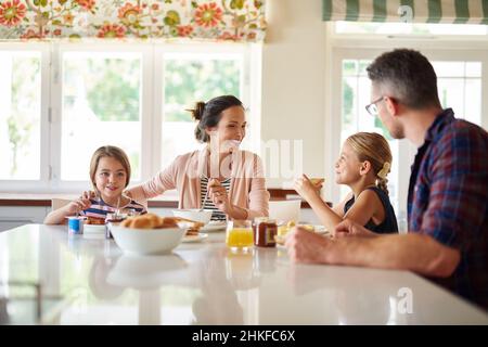 Spaß am Frühstückstisch. Aufnahme einer Familie, die zusammen frühstückte. Stockfoto