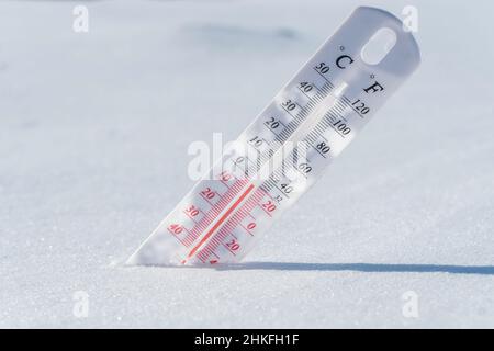 Thermometer im Schnee. Klima, Wetter, Prognose. Außentemperaturen. Thermometer im Schnee zeigt Temperaturen unter Null an. Niedrige Temperaturen in Stockfoto