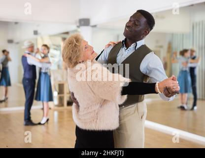 Mann und ältere Frau, die im Tanzsaal einen Tanzsaal tanzen Stockfoto