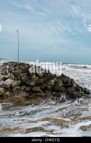 Barrikade mit schwarzem Sand, Kappil, Kerala Stockfoto