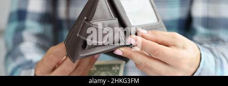 Frau goss Dollarscheine und Münzen aus der Ledertasche auf den Tisch mit Dokumenten aus der Nähe Stockfoto