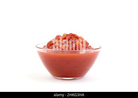 Gehackte Tomaten in Tomatensaft in Glasschüssel isoliert auf weißem Hintergrund Stockfoto