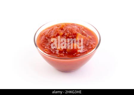 Gehackte Tomaten in Tomatensaft in Glasschüssel isoliert auf weißem Hintergrund Stockfoto