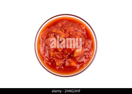 Gehackte Tomaten in Tomatensaft in Glasschüssel isoliert auf weißem Hintergrund Draufsicht Stockfoto