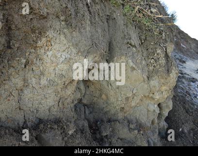 Bild eines natürlichen Hintergrunds aus Lehmboden, der vor der Küste abgeschnitten ist Stockfoto