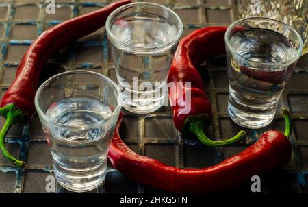 Ein Glas Wodka mit Paprika auf dunklem Hintergrund Stockfoto