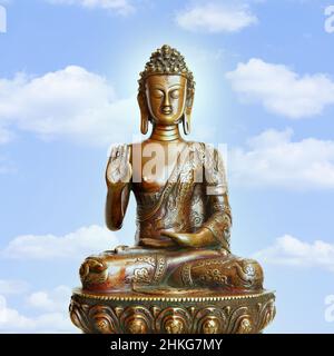 Figur des sitzenden Buddha und des blauen Himmels mit Wolken im Hintergrund Stockfoto