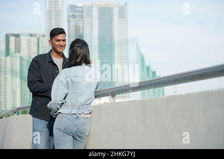 Junges Paar in der Liebe stehen auf der Brücke, reden und flirten Stockfoto