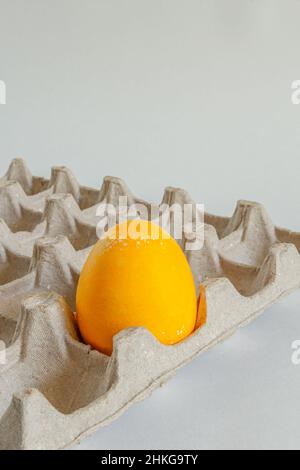 Ein gelbes Ei in einem Karton. Fest der hellen Ostern. Stockfoto