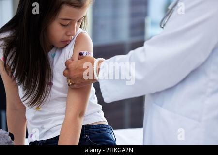 Es wird bald alles besser sein. Aufnahme eines kleinen Mädchens, das von einem Arzt in einem Krankenhaus impfen musste. Stockfoto