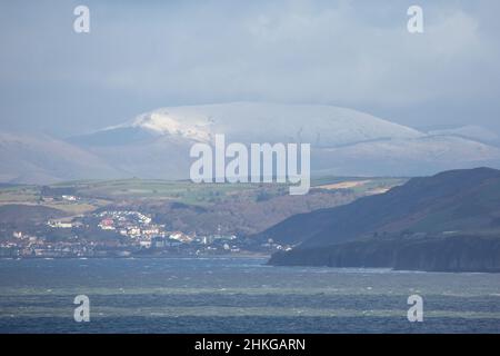 Llanon, Ceredigion, Wales, Großbritannien. 04th Februar 2022 UK Wetter: Kalter windiger Tag in llanon, Mitte Wales. Mit Blick über die Cardigan-Bucht auf die Küstenstadt Aberystwyth und die schneebedeckten Berge von snowdonia in der Ferne. © Ian Jones/Alamy Live News Stockfoto