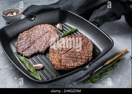 Geröstet auf Grillpfanne Rindfleisch marmorierte Fleischsteaks. Grauer Hintergrund. Draufsicht Stockfoto