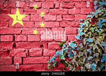 Chinesische Grunge-Flagge auf Ziegelmauer mit Efeu-Pflanze, Land Symbol Konzept von China Stockfoto