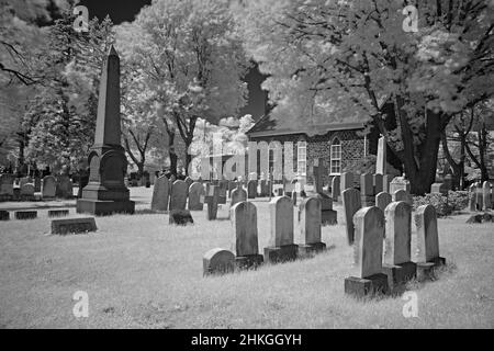 Ein sehr alter Friedhof in einem Hof der englischen Reform Church aus dem Jahr 1776. Dieses infrarote, abstrakte, schwarz-weiße Foto ist ein beängstigendes und ein guter Look für Halloween. Stockfoto