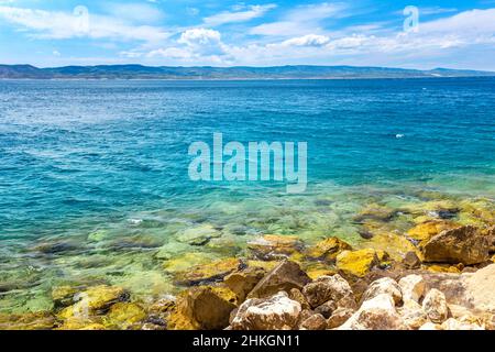 Felsküste der Adria im Ferienort Brela in Kroatien. Im Hintergrund ist die Insel Brac. Stockfoto