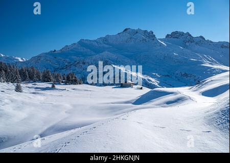 Riesige Alpine Mountains mit Blick auf eine kleine Holzhütte, die sich auf der Insel zu Fuß befindet. Stockfoto