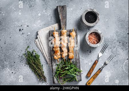 Gegrillter Shish Kebab mit Hühnerfleisch, Geflügelspieße mit Salat. Grauer Hintergrund. Draufsicht Stockfoto