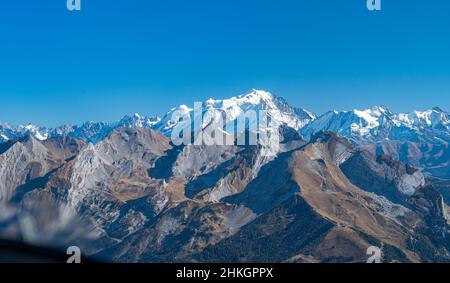 Schneebedeckte Bergkette hoch stehend hinter einem felsigen Gebirgszug in Europa. Stockfoto