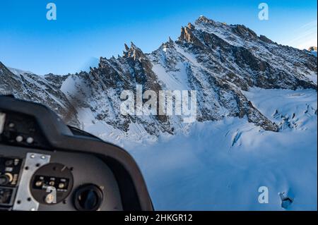 Atemberaubende Spitzenaufnahme eines schneebedeckten Berges, aufgenommen von einem Hubschrauber Stockfoto