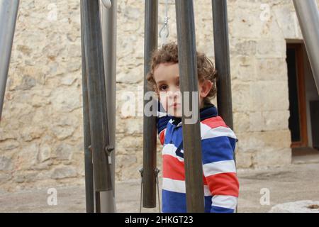 Mein Sohn spielt gerne zwischen den Bars Stockfoto