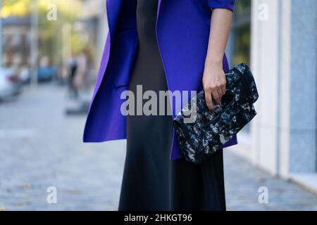 Eine elegante Frau in stilvollem Outfit posiert auf einer Stadtstraße. Stockfoto